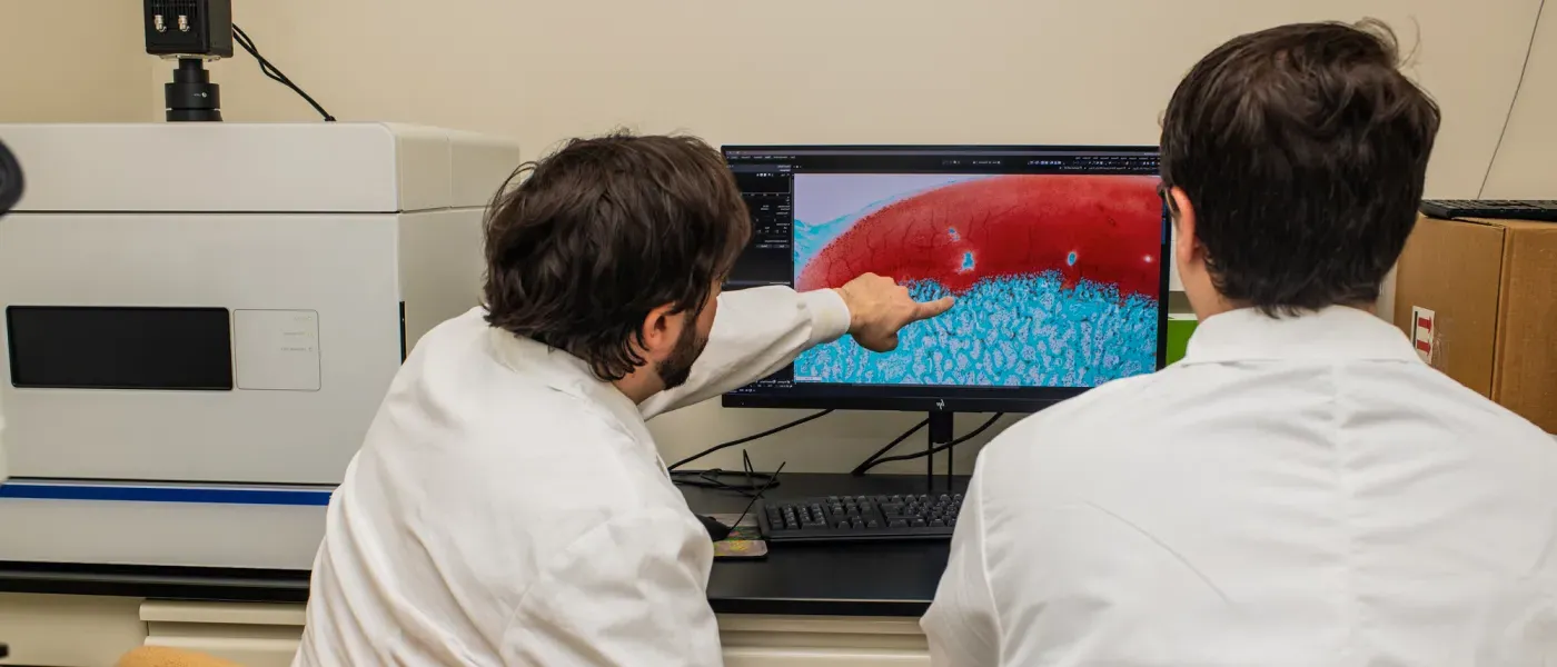 Two students review a blown up microscope image on the computer